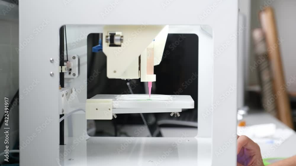 Researcher adjusting a 3D bioprinter to 3D print cells onto an electrode. 4k video. Researcher adjusting a 3D bioprinter to 3D print cells onto an electrode. 4k video.