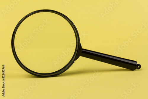 magnifying glass loupe search symbol on yellow background with copy space