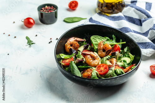 Shrimps salad, cherry tomatoes, cucumber and mixed leaves, grilled prawn shrimps. Healthy food. Clean eating. place for text, top view © Надія Коваль