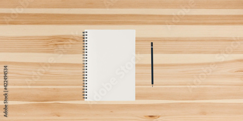 Modern workplace with blank paper and pencil copy space on wood background. Top view. Flat lay style.