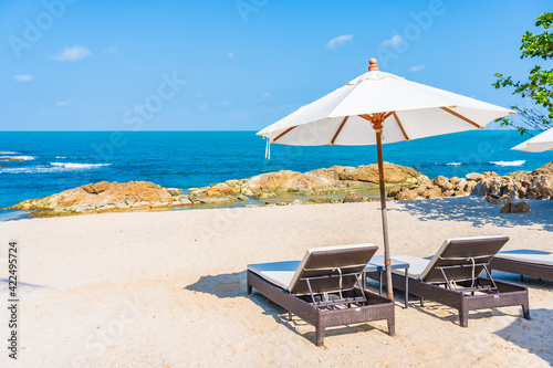 Beautiful tropical beach sea with umbrella and chair around white cloud and blue sky