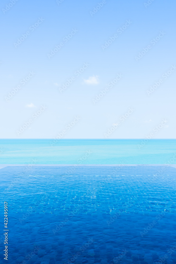 Fototapeta premium Beautiful private infinity outdoor swimming pool with sea ocean white cloud and blue sky view