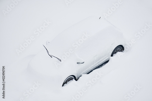 Snow-covered car on the parking place after the strong snowstorm