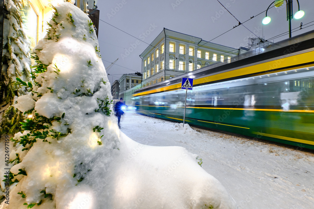 Aleksanterinkatu street during the strong snowstorm. The tram is moving on the street. Helsinki, Finland.