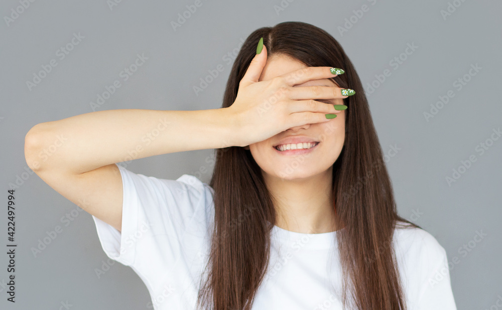 Happy woman closing eyes with hand going to see surprise prepared by boyfriend standing and smiling in anticipation for something wonderful. Young lady covering face with hand Happy woman closing eyes with hand going to see surprise prepared by boyfriend standing and smiling in anticipation for something wonderful. Young lady covering face with hand