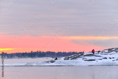 Obraz na płótnie Ice-covered Baltic seashore in Finland. Fog over the sea during a strong frost in the sunset. w salonie