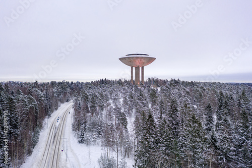 Espoo, Finland - February 1, 2021: Aerial view of Haikaranpesa water tower in winter day. Snow-covered street and city park