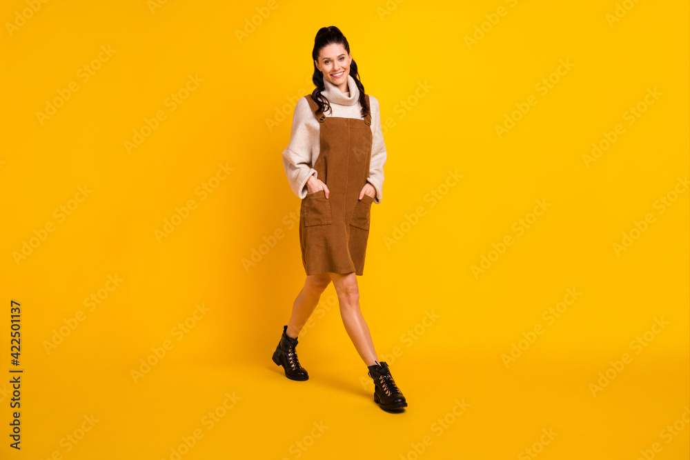 Photo of lovely cute lady go hands wear brown overall pullover footwear isolated yellow color background
