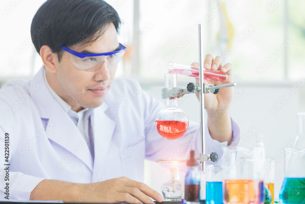 Asian scientist in the laboratory working at lab with test tubes. Asian man scientists researching for Healthcare and biotechnology in laboratory. Concept Production of antiviral drug. Asian scientist in the laboratory working at lab with test tubes. Asian man scientists researching for Healthcare and biotechnology in laboratory. Concept Production of antiviral drug.