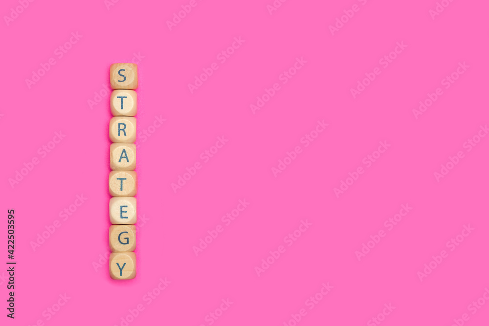 La palabra estrategia escrita en cubos de madera sobre un fondo rosa fuerte liso y aislado. Vista superior. Copy space La palabra estrategia escrita en cubos de madera sobre un fondo rosa fuerte liso y aislado. Vista superior. Copy space