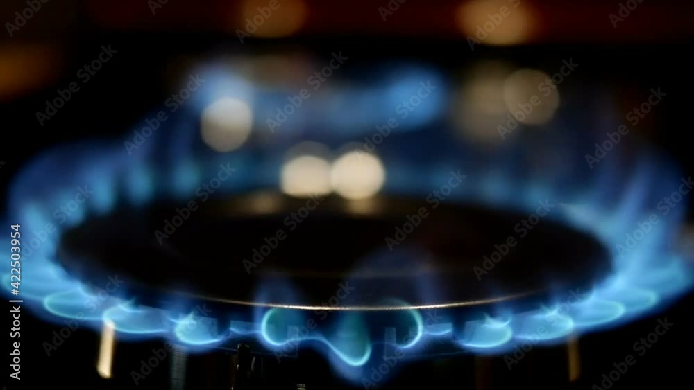 Process of burning and appearing blue flame of gas methane or propane on kitchen gas stove. Kitchen burner switching. Natural gas inflammation. Selective focus. Slow motion. Close-up. Process of burning and appearing blue flame of gas methane or propane on kitchen gas stove. Kitchen burner switching. Natural gas inflammation. Selective focus. Slow motion. Close-up.