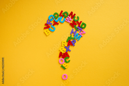 Alphabet forming a question mark on a yellow background Concept of education and knowledge photo