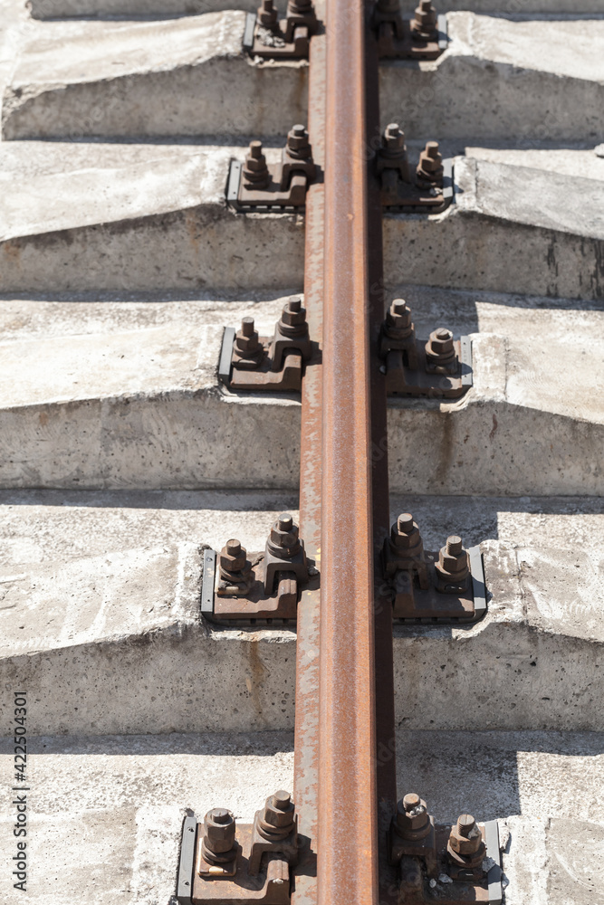Rusty steel rail mounted on gray concrete sleepers Rusty steel rail mounted on gray concrete sleepers