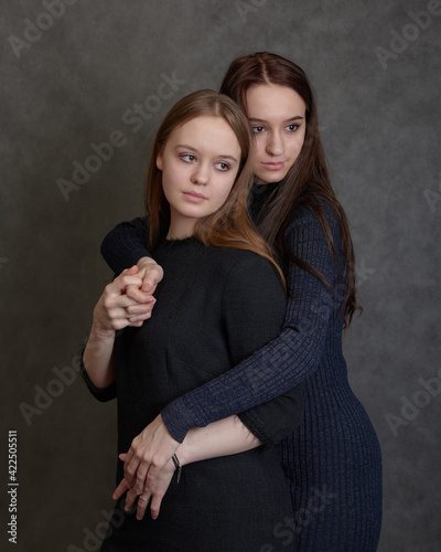 Two young women hugging and looking apart