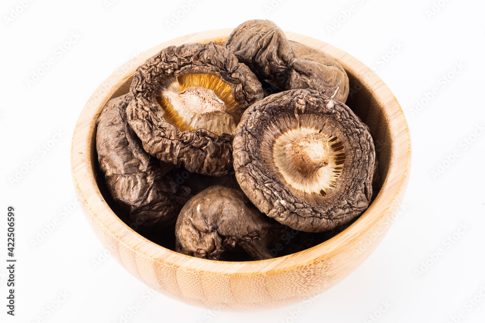 A lot of dried shiitake mushrooms in the wooden bowl A lot of dried shiitake mushrooms in the wooden bowl
