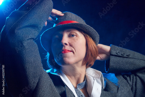 Portrait of ugle middle-aged woman with hat. Model posing in funny male style in the Studio. photo