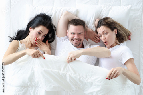 Canvastavla Man lying with two lovers in bed