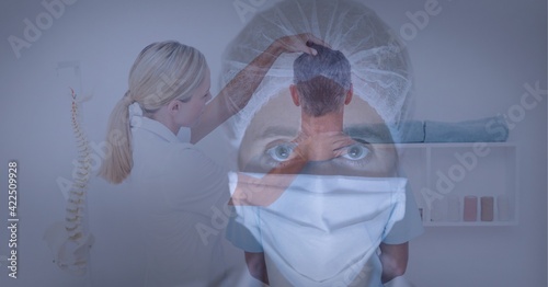 Portrait of female health worker wearing face mask against female doctor doing neck adjustment