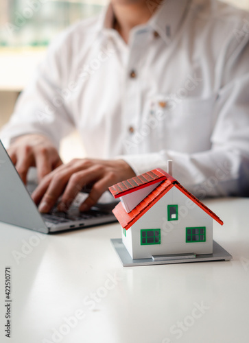 Home Loans, Home Loan Approval and Insurance Concepts, Businessmen are searching for a home online using a laptop computer.