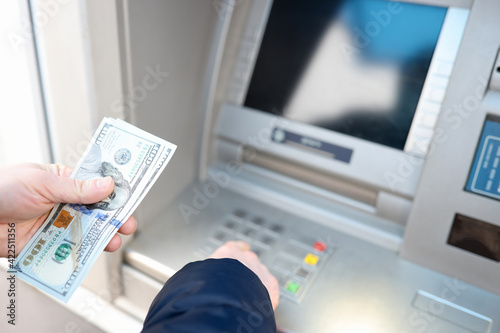 Man withdrawing american dollars from ATM closeup