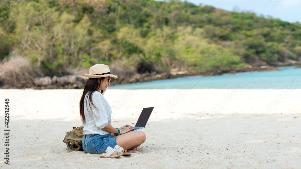 Lifestyle freelance woman using laptop working and relax on the beach.  Asia people success and together your work pastime and meeting conference on internet in holiday