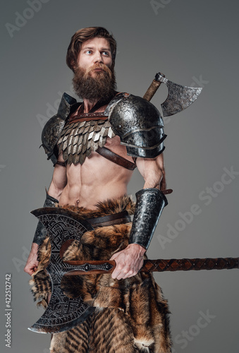 Proud scandinavian soldier from the past wearing armour and holding axe