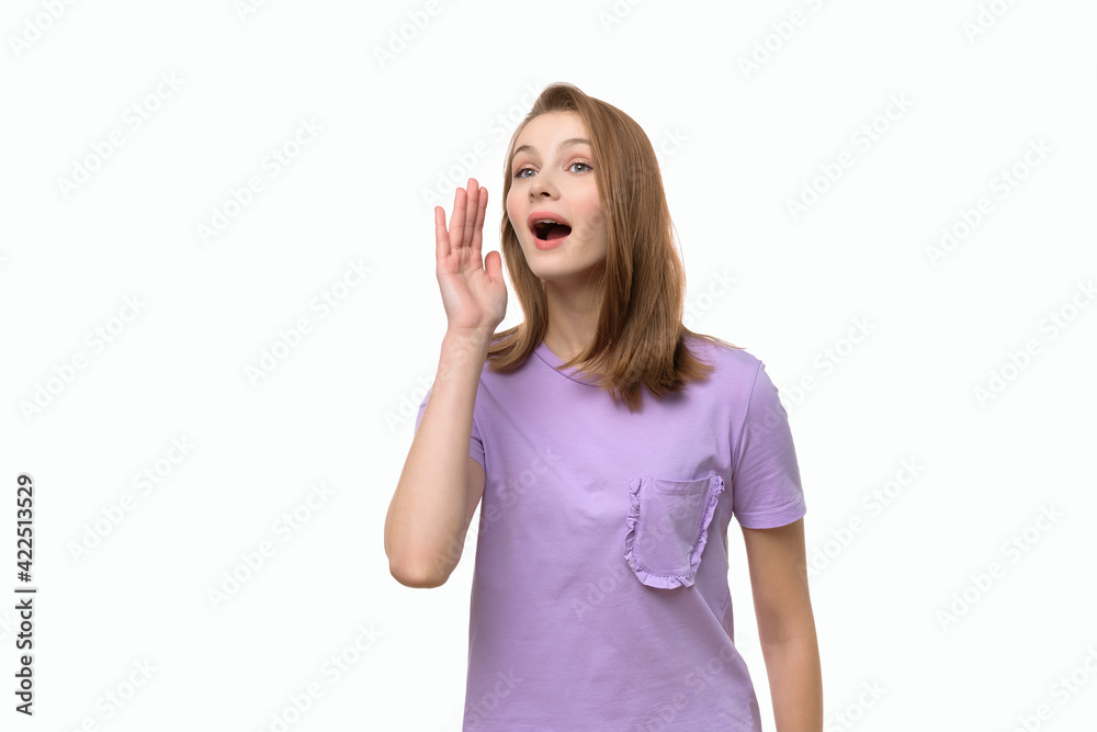 Beautiful young woman shouting and announcing something having combined hands in a megaphone Beautiful young woman shouting and announcing something having combined hands in a megaphone