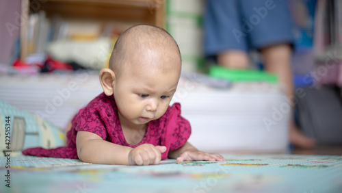Asian Baby Girl who is 6 months old is rolling over and lifting her head up high and looking around Baby Development