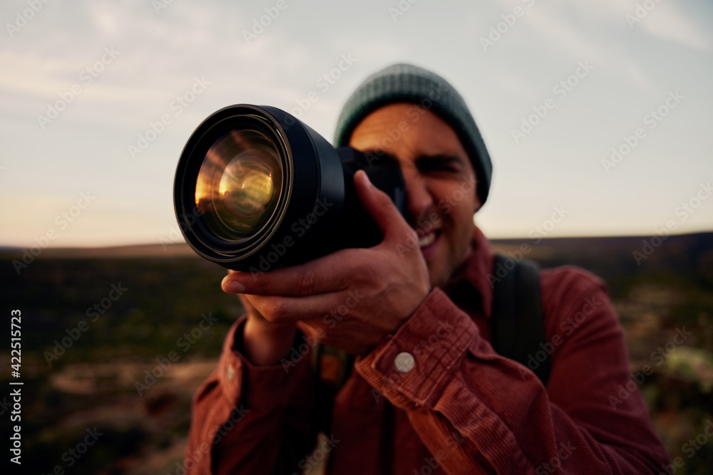 Young hiker taking photos of mountains and beautiful sunrise with professional camera Young hiker taking photos of mountains and beautiful sunrise with professional camera
