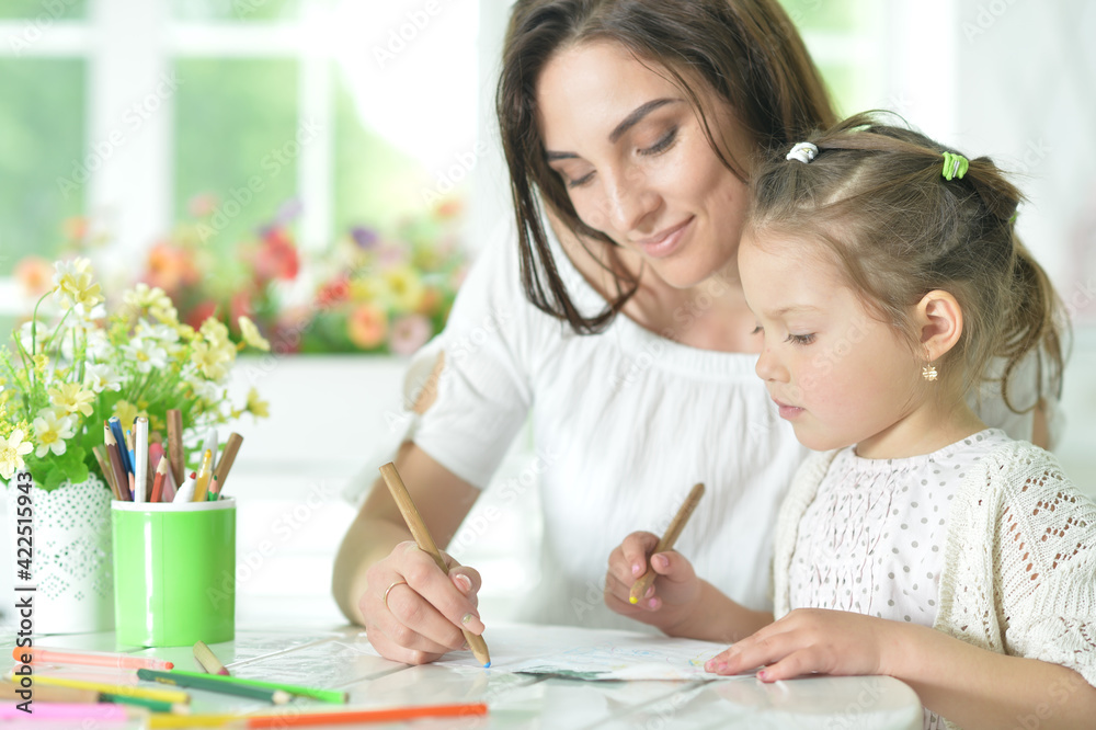 cute girl with mother drawing at the table