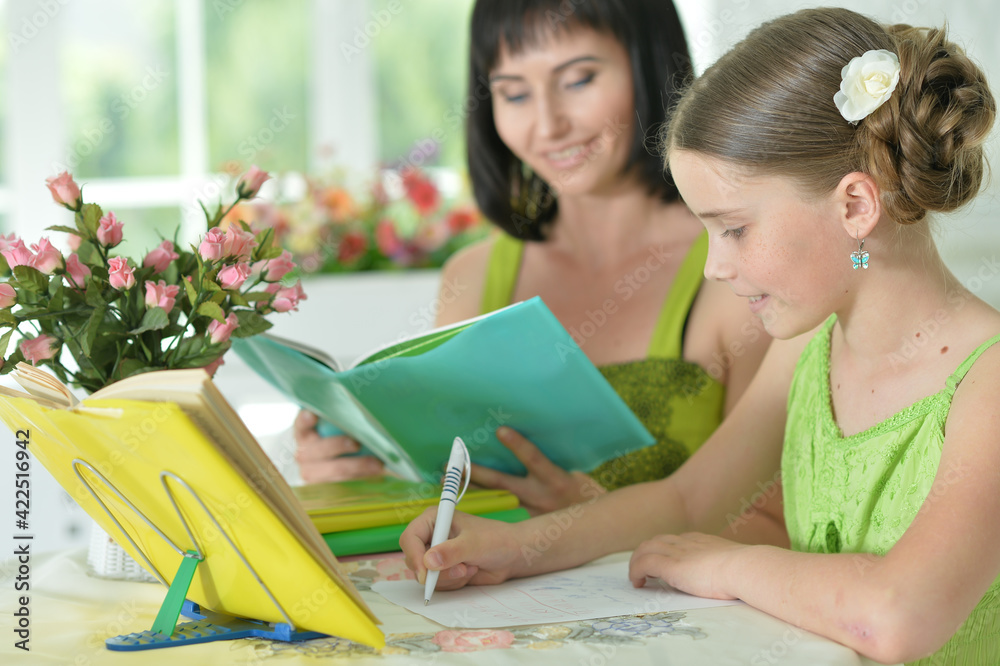 little cute girl and mother doing homework  at home
