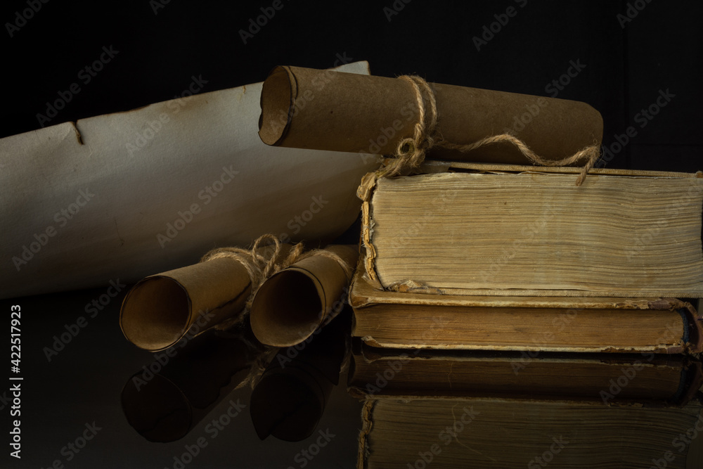 Ancient Unfolded and Rolled Scrolls and Ancient Books on Black Background