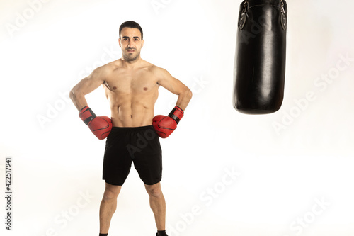 Athlete man training with boxing gloves on white background. © robcartorres