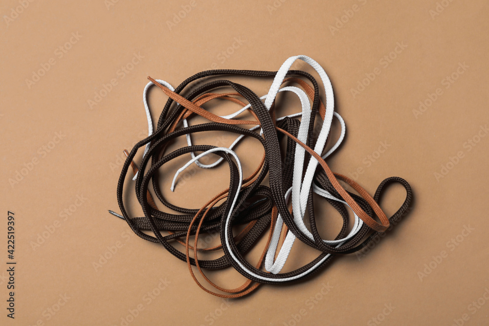 Different shoelaces on brown background, flat lay Different shoelaces on brown background, flat lay