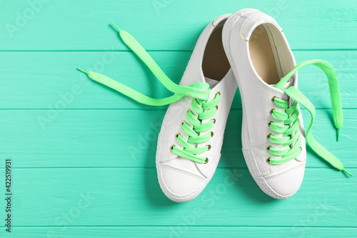 Pair of stylish shoes with laces on turquoise wooden background, flat lay. Space for text