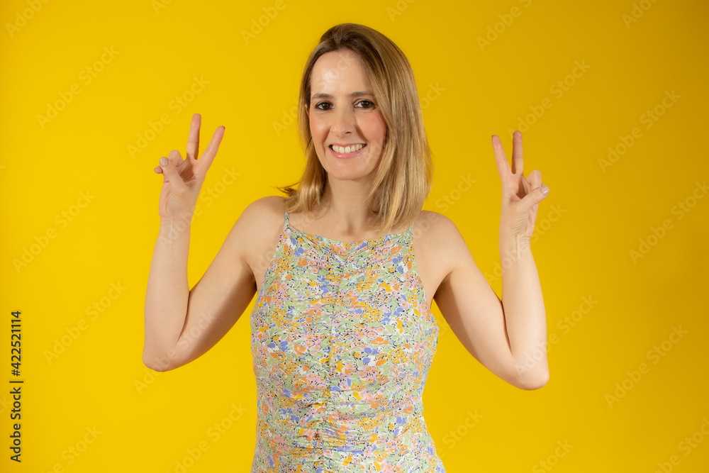 Young woman over isolated background smiling and showing victory sign Young woman over isolated background smiling and showing victory sign