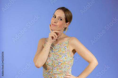 Portrait of a pensive casual woman looking away at copy space isolated over purple background