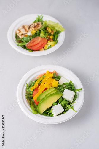 Wallpaper Mural Two diet light salads with chicken, tomatoes, avocado, greens, white background. Healthy lunch. Take away food in eco paper plates. Concept restaurant delivery, environment protection. Torontodigital.ca