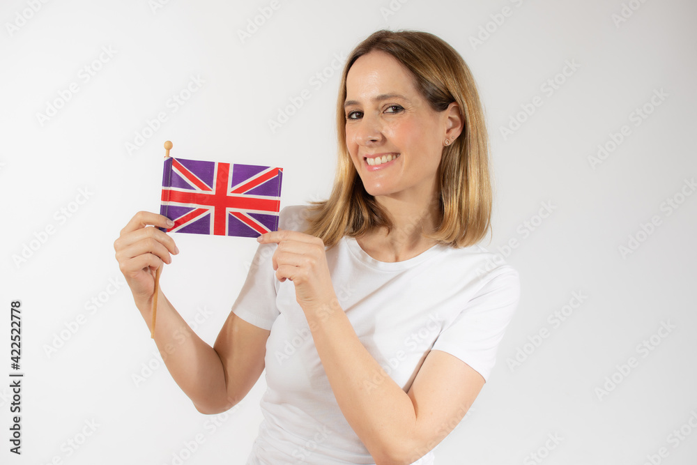 Portrait of a smiling casual young woman holding british flag isolated over white background Portrait of a smiling casual young woman holding british flag isolated over white background