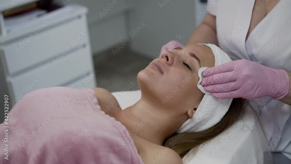 Pretty woman having cleansing the skin with swabs during cosmetology treatment