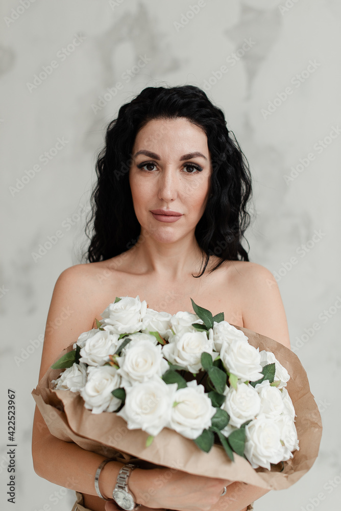 brunette model covers her naked breasts with a large bouquet of flowers brunette model covers her naked breasts with a large bouquet of flowers