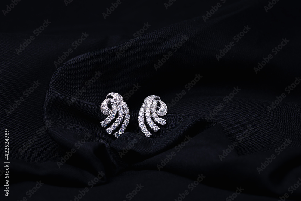 white gold diamond earrings isolated on black background white gold diamond earrings isolated on black background