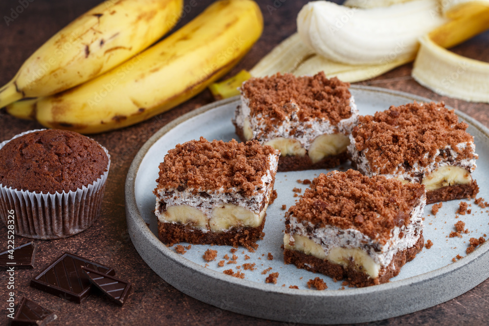 Delicious homemade chocolate dessert with banana, ricotta (cremcheese, mascarpone) and brownie. Mole cake. Portions of pie in a gray plate. Selective Focus