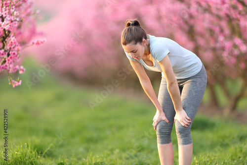 Exhausted runner resting after run in a pink field