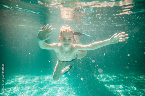 Cute little boy underwater in swimming pool 
