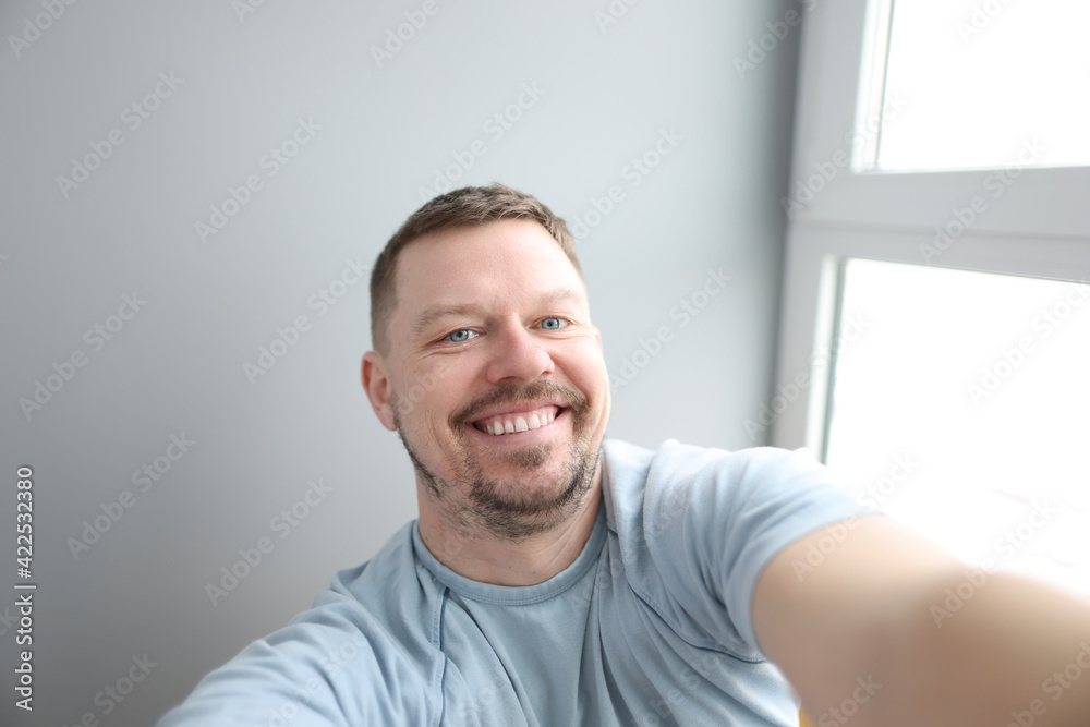 Young smiling man taking selfie at home Young smiling man taking selfie at home