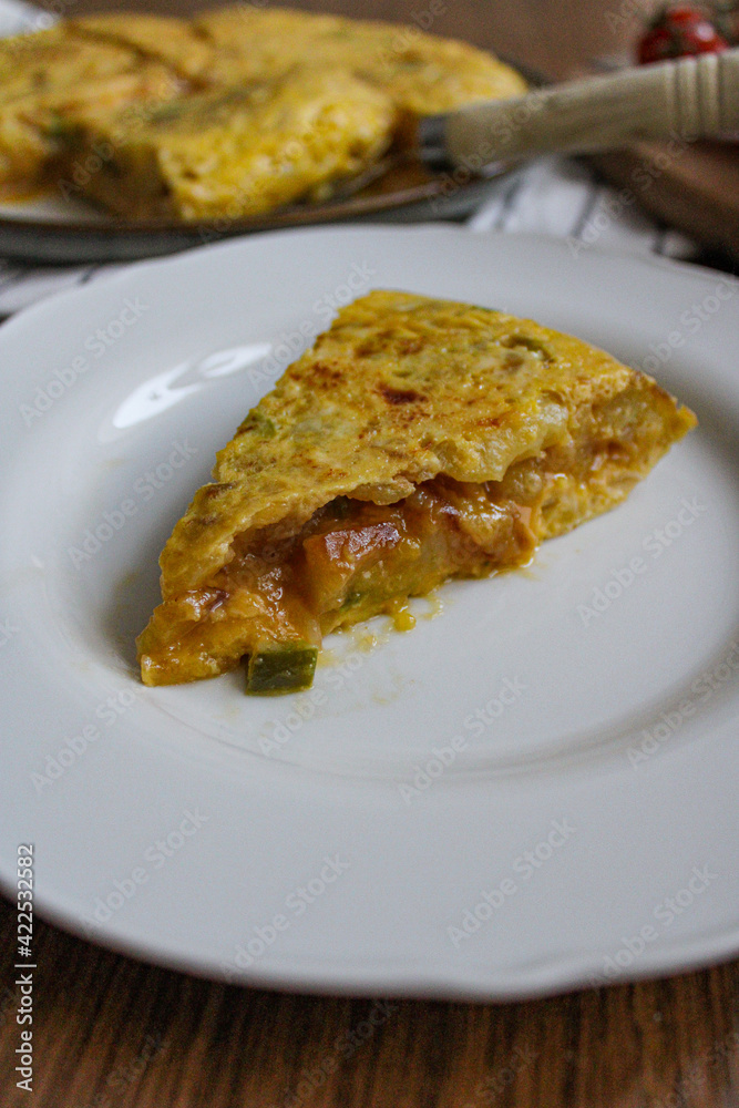 Tortilla pincho. Plated Spanish potato omelette pintxo on a set table. Serving slice of a tapa. 