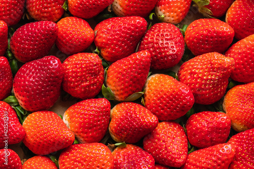 close-up on delicious red strawberries tightly arranged on a background