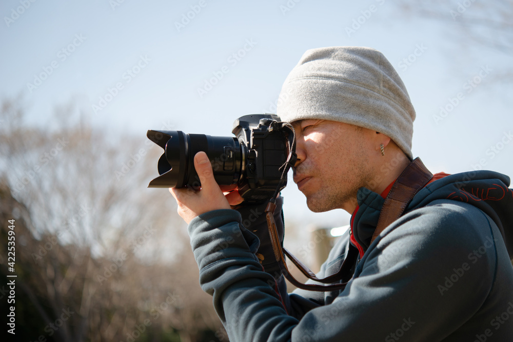 一眼レフカメラで写真を撮る男性