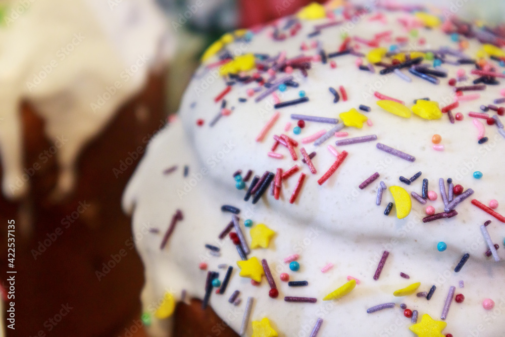 Easter spring holidays sweet bread, paska close-up composition decorated with sugar icing on blurred background. Orthodox handmade kulich with topping
